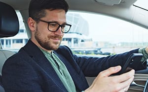 Salesman reviewing customer data on phone in car